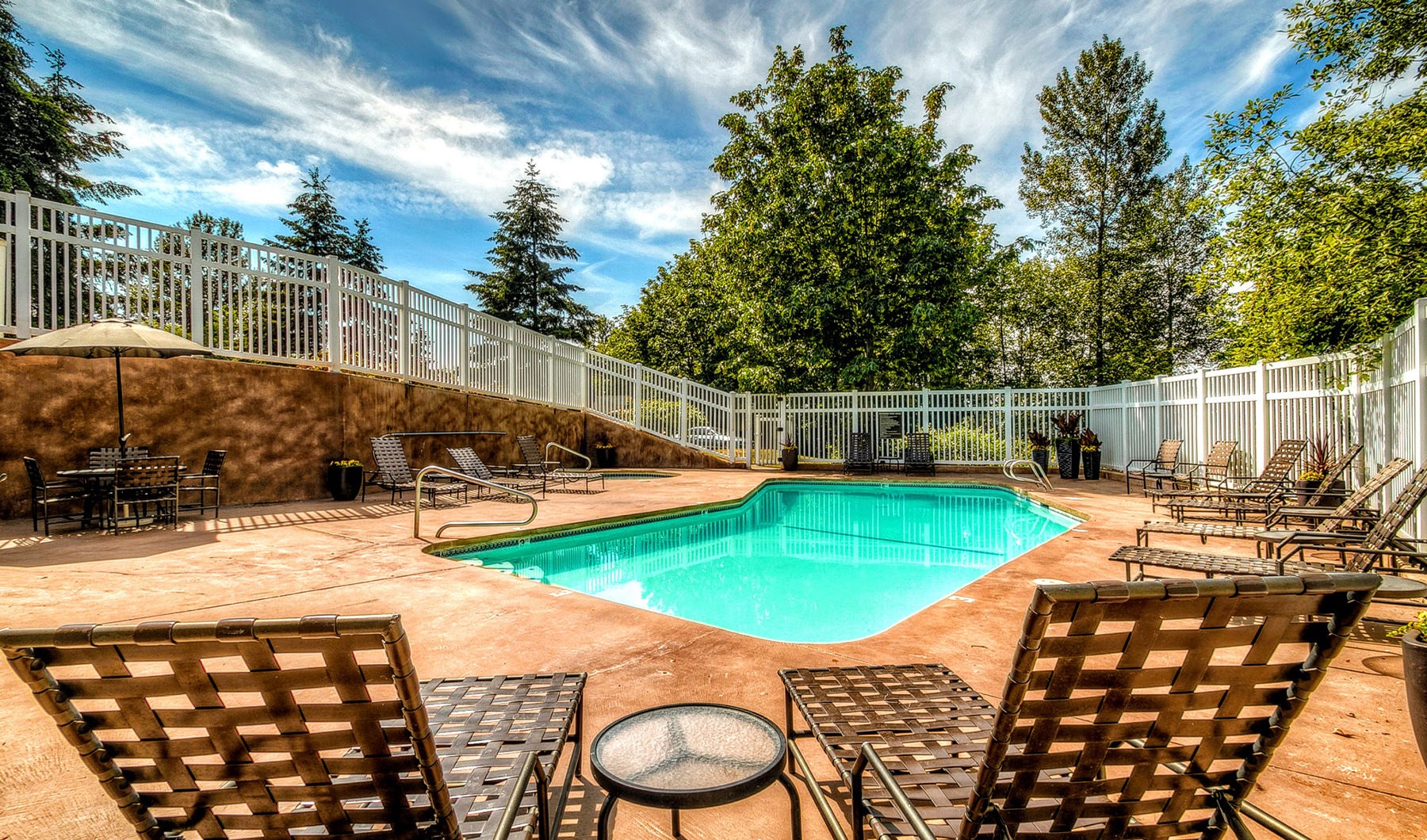 Outdoor heated pool with lounge chairs
